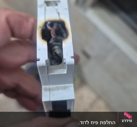 חלק חשמלי שרוף מוחזק ביד